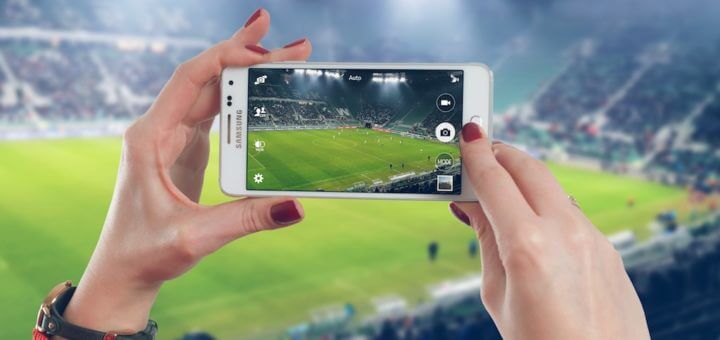 con il telefono smartphone allo stadio a vedere la partita di calcio