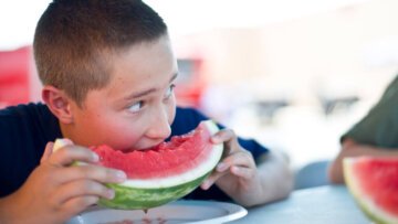 ragazzo che mangia un'anguria